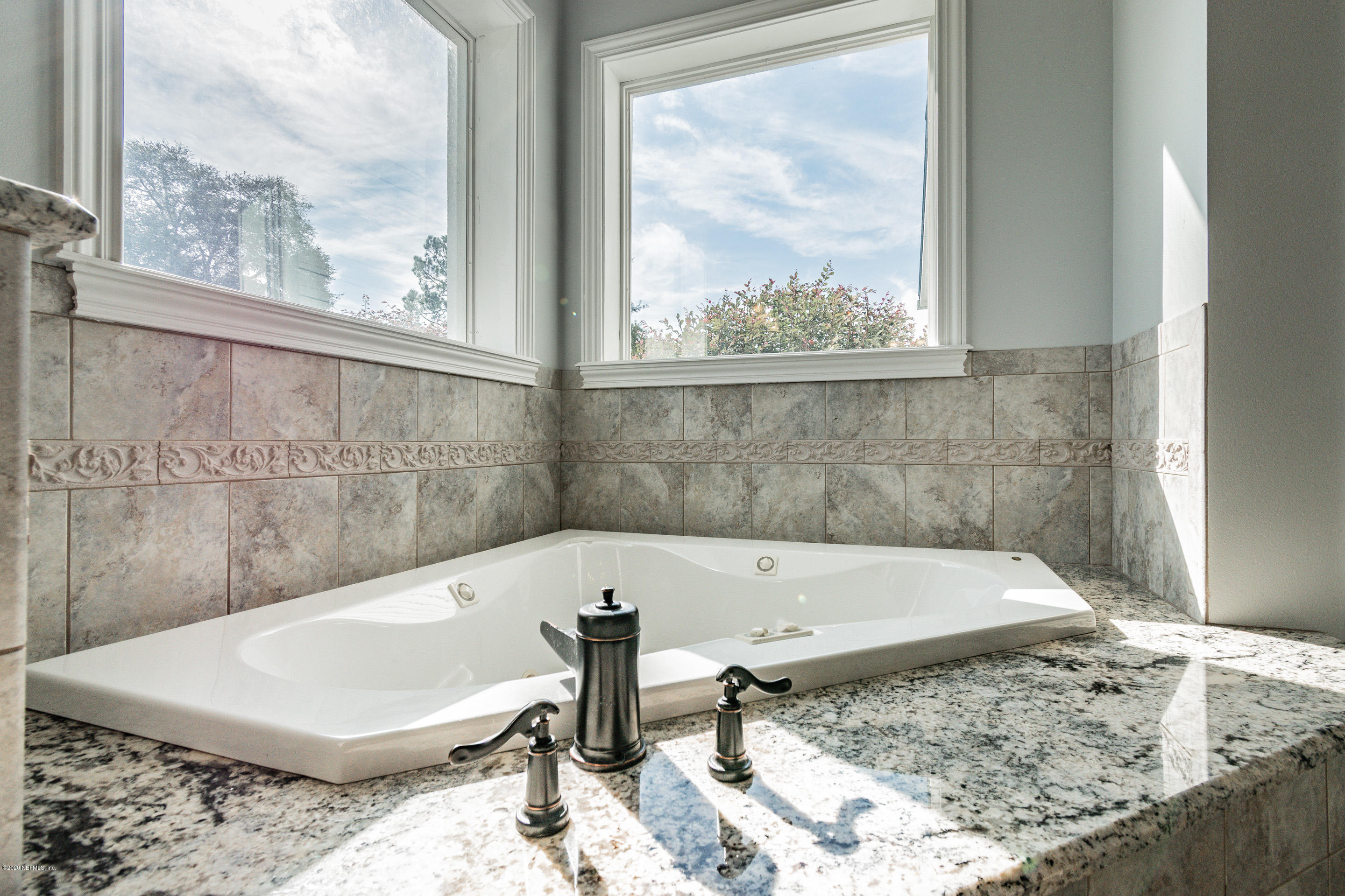 14689 Diamond Ranch Drive Jacksonville, FL 32234 - Photo 36 of 76 a bath tub sitting in a bathroom next to a window