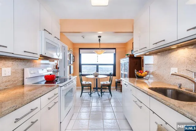 a kitchen with stainless steel appliances granite countertop a sink stove and cabinets
