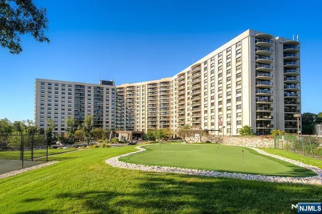 a view of building with a big yard and large trees