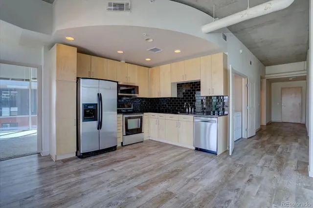 a kitchen with stainless steel appliances a refrigerator and a stove top oven