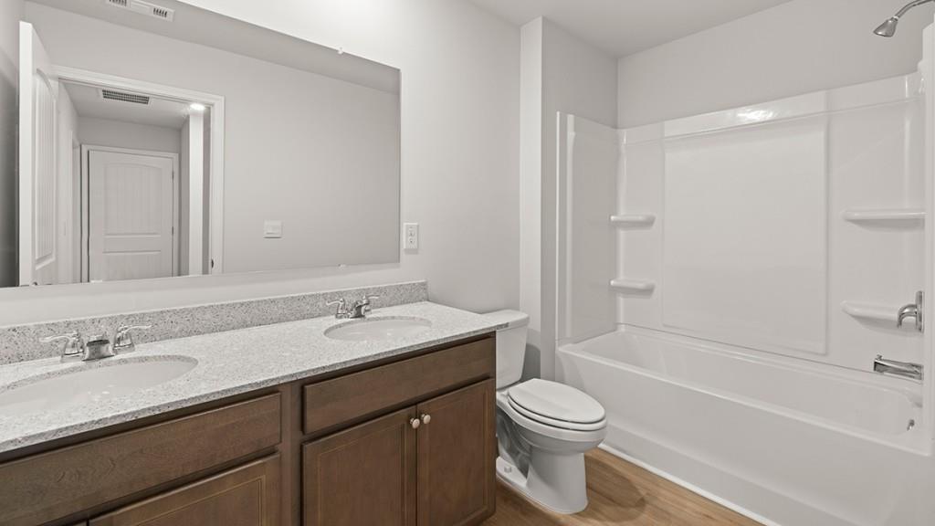 3245 Ryker Road, Unit 306 Gainesville, GA 30507 - Photo 23 of 35 a bathroom with a granite countertop sink a toilet and a bathtub