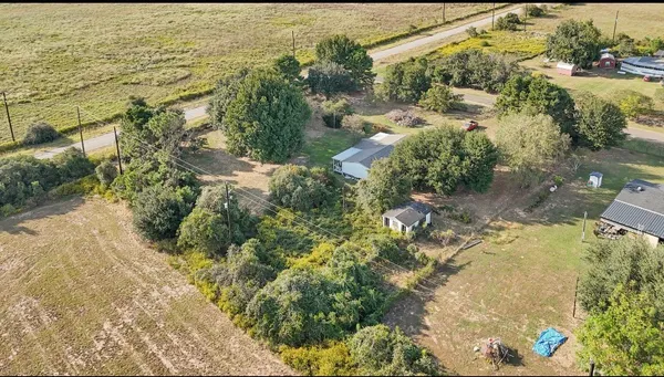 an aerial view of a house with a yard and lake view