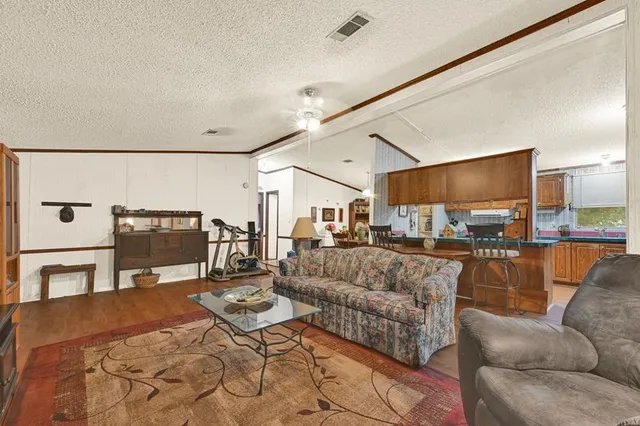 a kitchen with stainless steel appliances granite countertop a stove a sink dishwasher and a microwave oven with wooden cabinets