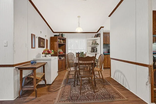 a kitchen with stainless steel appliances granite countertop a stove top oven a sink dishwasher and a refrigerator with wooden floor