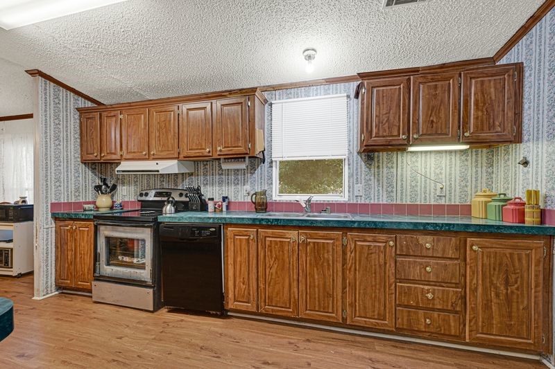 35494 Betka Road Hempstead, TX 77445 - Photo 21 of 37 a kitchen with stainless steel appliances granite countertop a stove a sink dishwasher and a microwave oven with wooden cabinets