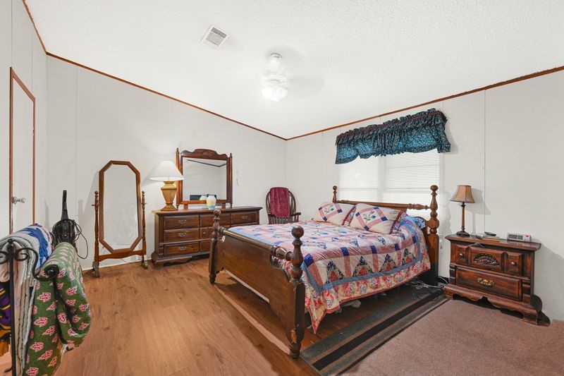 35494 Betka Road Hempstead, TX 77445 - Photo 24 of 37 a bedroom with a bed and a dresser with the mirror