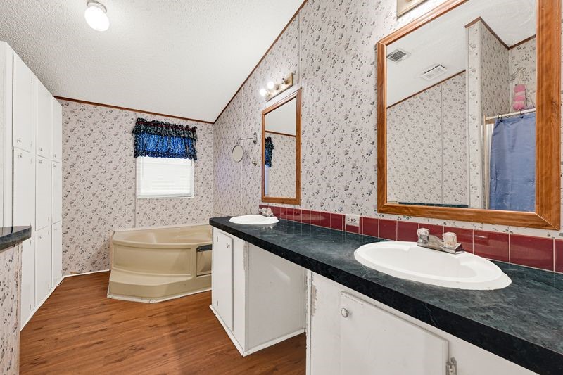 35494 Betka Road Hempstead, TX 77445 - Photo 26 of 37 a bathroom with a granite countertop sink a mirror a vanity and a shower