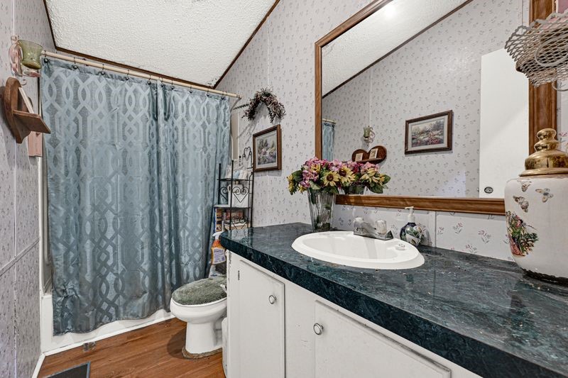 35494 Betka Road Hempstead, TX 77445 - Photo 33 of 37 a bathroom with a granite countertop sink toilet and a mirror