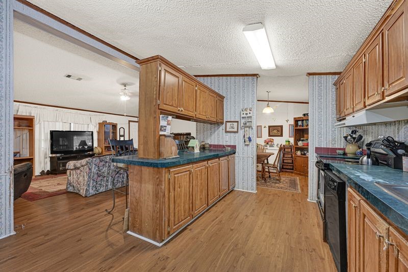 35494 Betka Road Hempstead, TX 77445 - Photo 4 of 7 a kitchen with stainless steel appliances granite countertop a stove top oven a sink dishwasher and a refrigerator with wooden floor