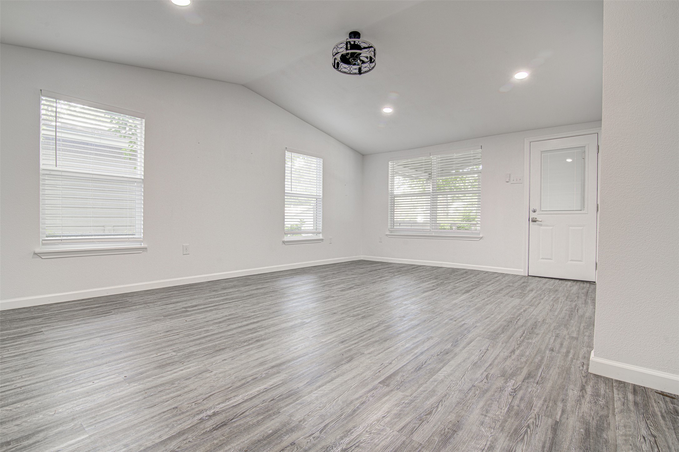 1807 San Jose Street Georgetown, TX 78626 - Photo 10 of 21 A spacious common area with vaulted ceilings and durable wood-look vinyl plank flooring awaits personalization.