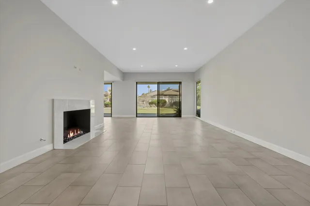 a view of an empty room with a fireplace and a window