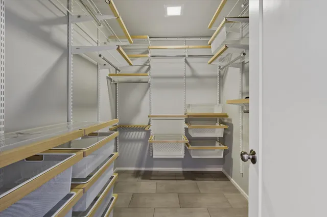 a view of walk in closet with empty racks