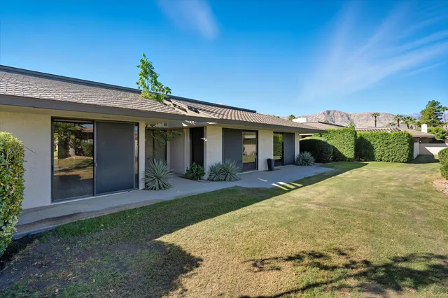 a front view of a house with a yard and potted plants