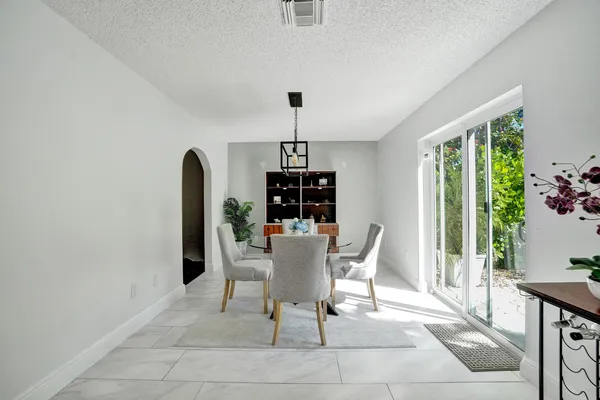a dining room with furniture potted plants and wooden floor