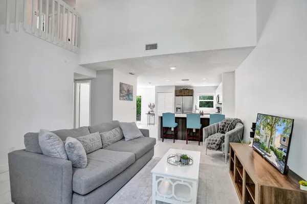 a living room with furniture kitchen view and a table