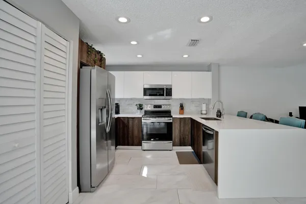 a kitchen with refrigerator and cabinets