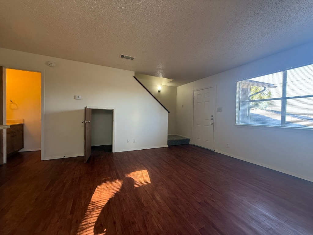 8102 Dunn Street, Unit A Austin, TX 78745 - Photo 11 of 21 an empty room with wooden floor cabinet and windows