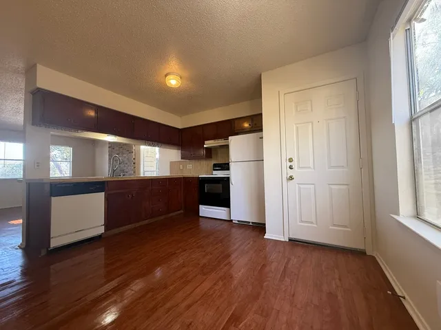 a view of kitchen with refrigerator and wooden floor