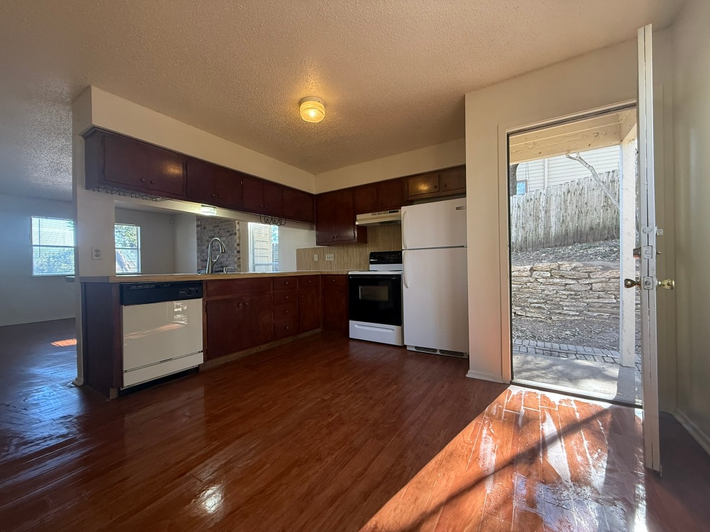 8102 Dunn Street, Unit A Austin, TX 78745 - Photo 8 of 21 a view of kitchen with refrigerator and wooden floor