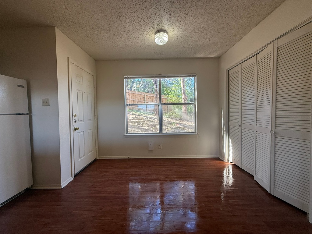 8102 Dunn Street, Unit A Austin, TX 78745 - Photo 9 of 21 an empty room with wooden floor and windows