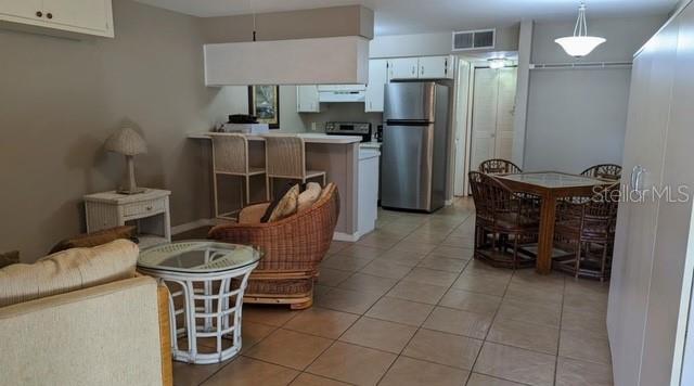 957 Southeast Mayo Drive, Unit 957 Crystal River, FL 34429 - Photo 20 of 22 a kitchen with a refrigerator a stove and chairs