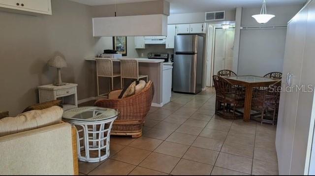 957 Southeast Mayo Drive, Unit 957 Crystal River, FL 34429 - Photo 9 of 22 a kitchen with refrigerator and chairs