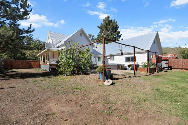 a view of a house with backyard and sitting area