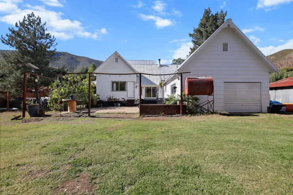 a view of a house with backyard and sitting area