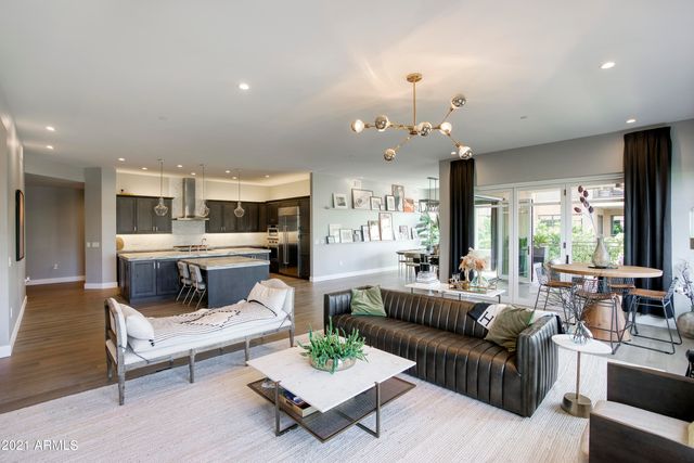 a living room with furniture kitchen view and large windows