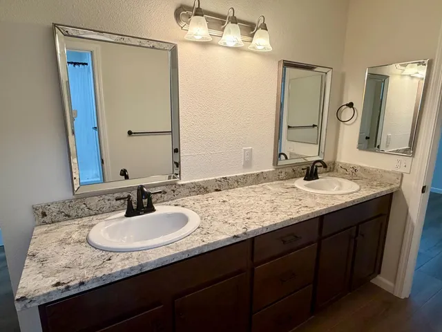 a bathroom with a granite countertop sink and a mirror