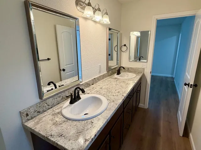 a bathroom with a granite countertop sink and a mirror