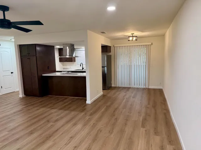 a view of a kitchen with wooden floor and stainless steel appliances