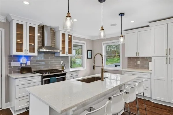 a kitchen with stainless steel appliances granite countertop a sink a stove and a refrigerator