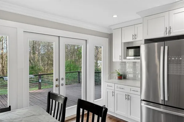 a kitchen with white cabinets and refrigerator