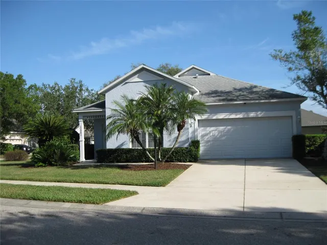 a view of a house with a yard and potted plants
