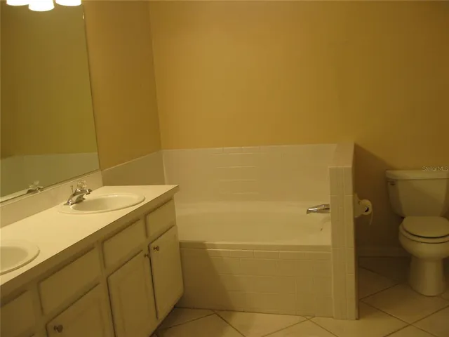 a bathroom with a granite countertop sink toilet and a mirror
