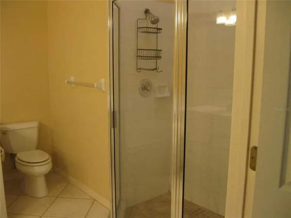 a bathroom with a granite countertop toilet and a shower