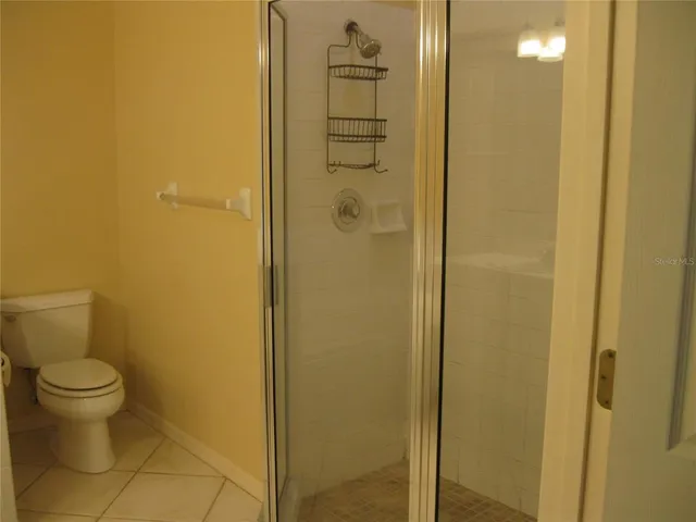 a bathroom with a granite countertop toilet and a shower