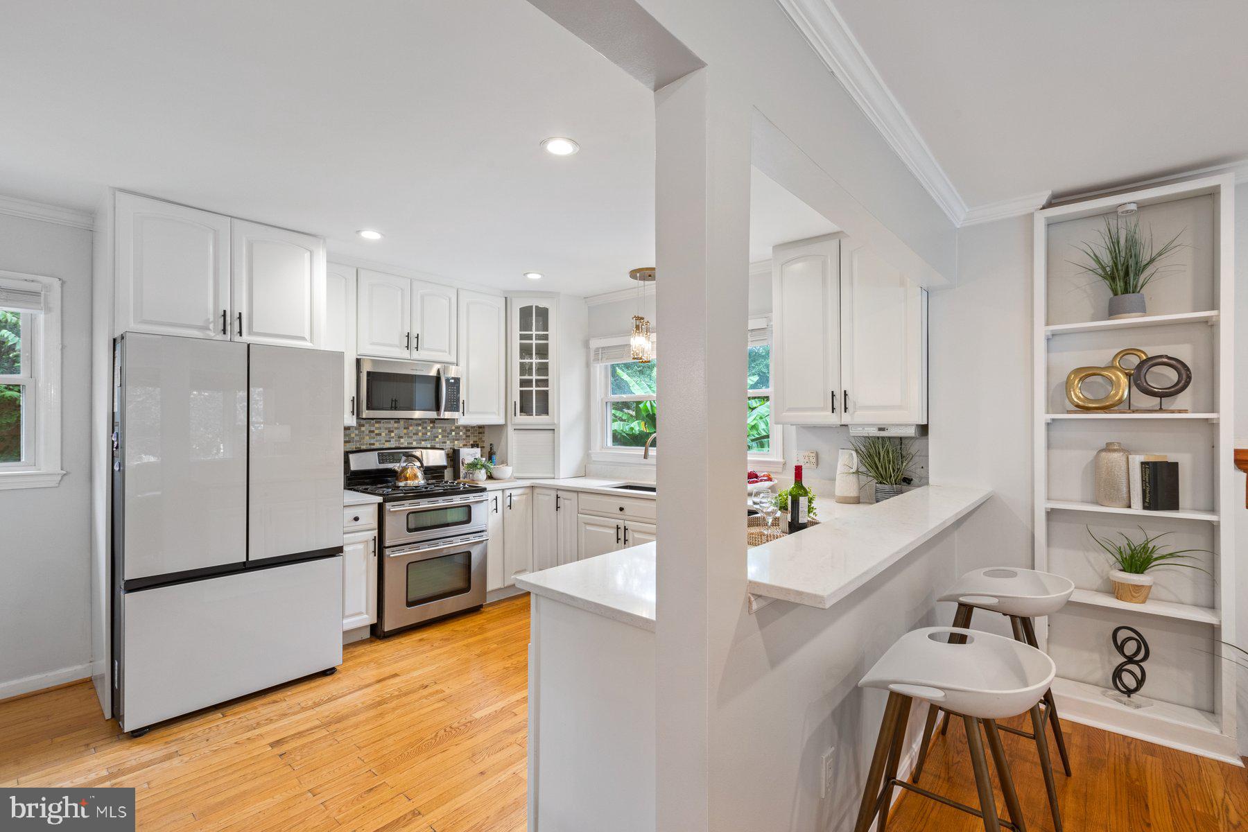 2605 Eccleston Street Silver Spring, MD 20902 - Photo 10 of 47 a kitchen with stainless steel appliances a refrigerator a stove a sink dishwasher and white cabinets with wooden floor