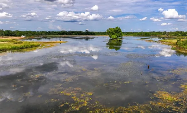 a view of a lake in front of house with a yard