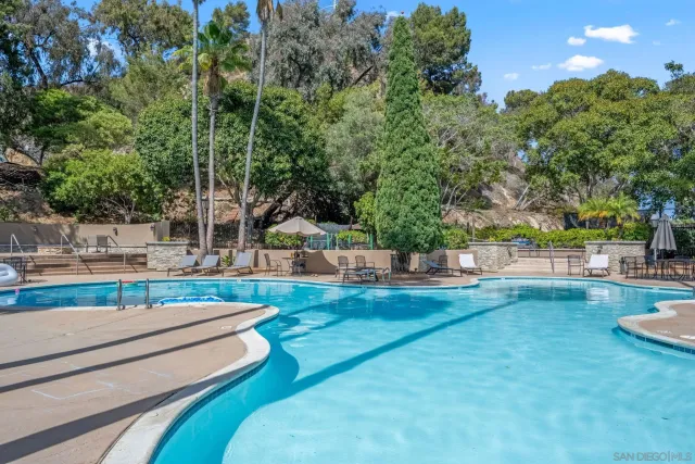 a view of a swimming pool with a couches and a fire pit
