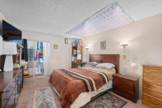 a bedroom with a bed a flat screen tv and dresser