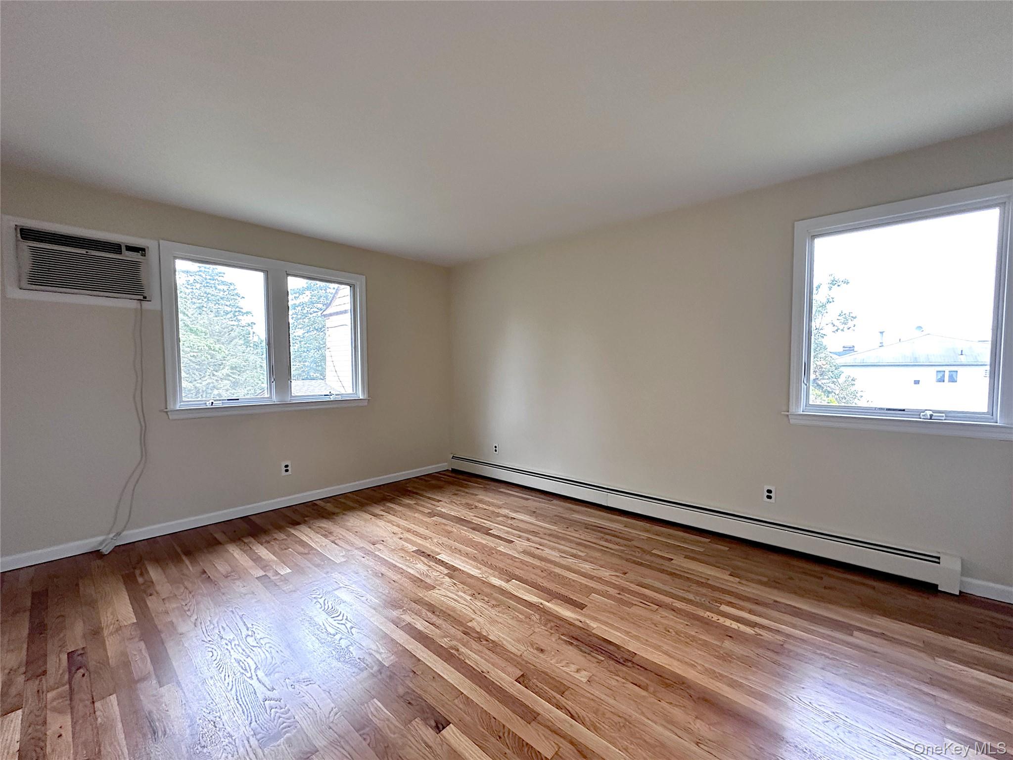 25 Acacia Terrace, Unit 2 New Rochelle, NY 10805 - Photo 11 of 28 a view of an empty room with wooden floor and a window