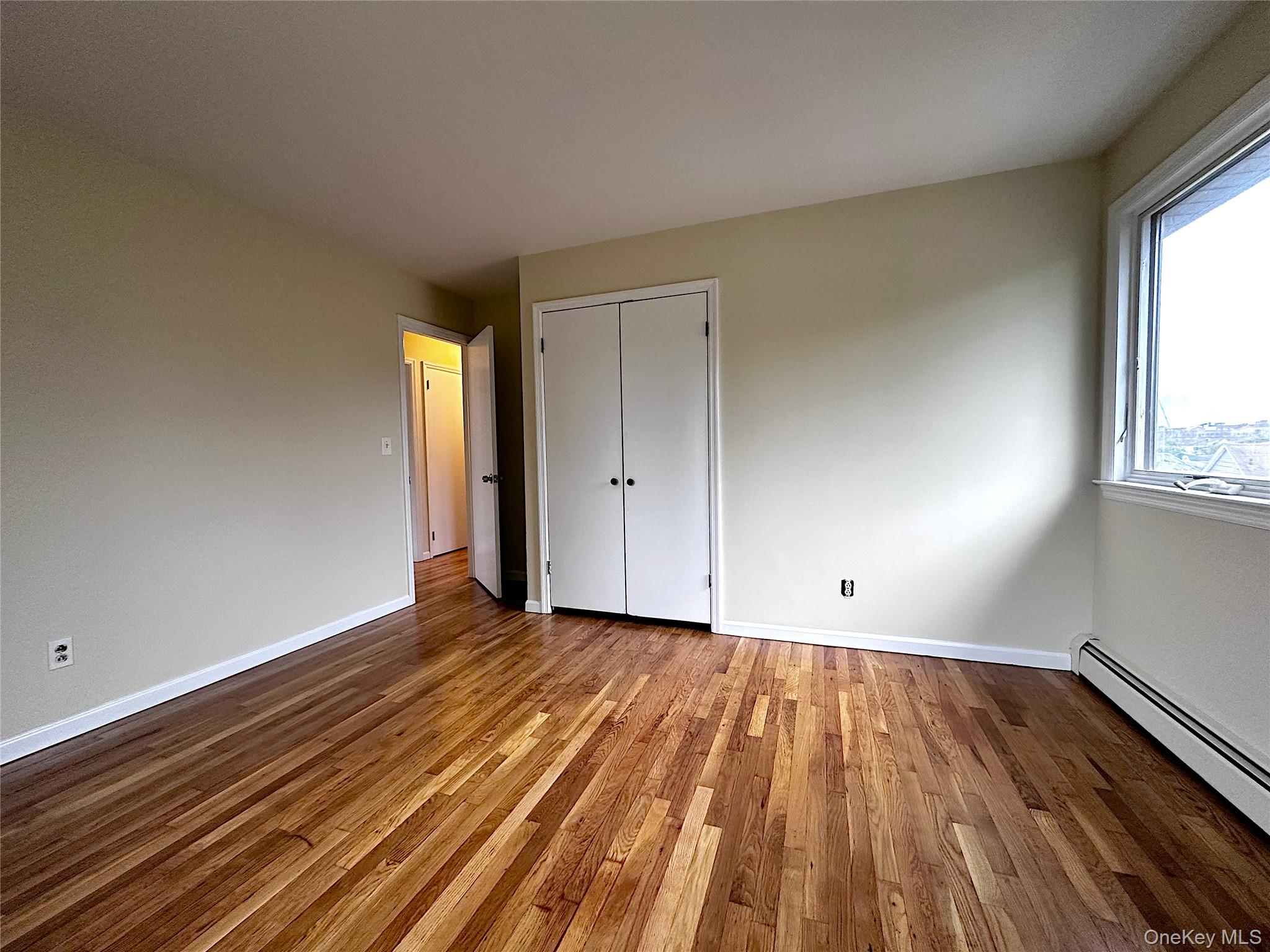 25 Acacia Terrace, Unit 2 New Rochelle, NY 10805 - Photo 18 of 28 a view of an empty room with wooden floor and a window
