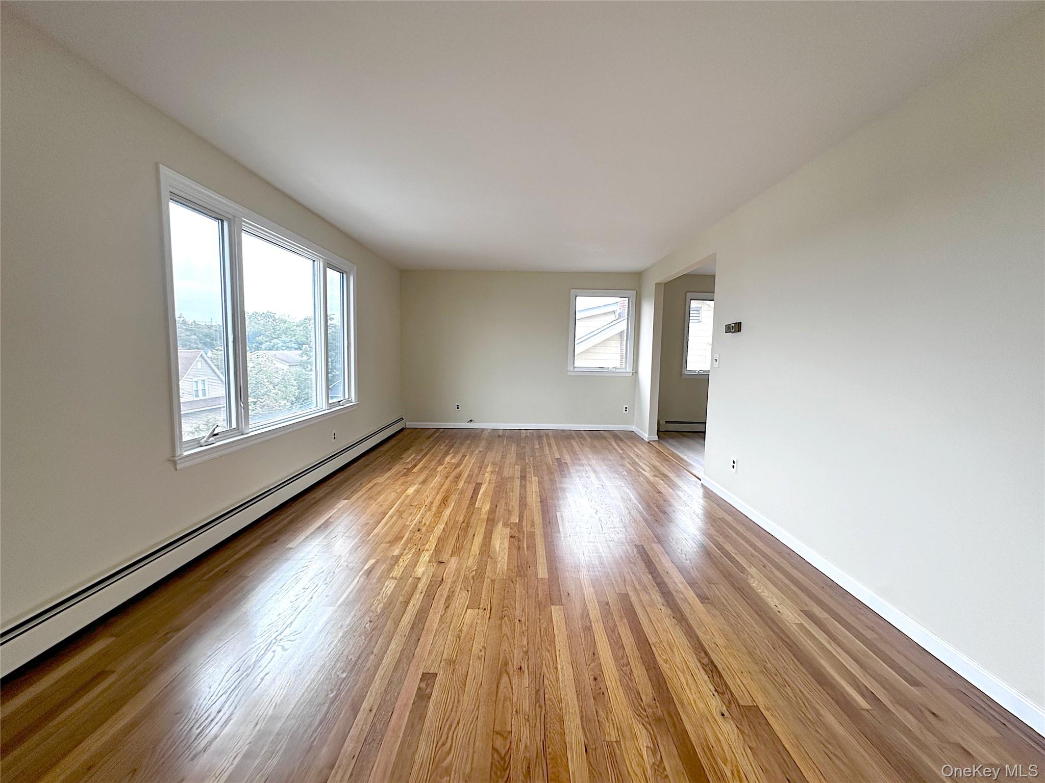 25 Acacia Terrace, Unit 2 New Rochelle, NY 10805 - Photo 6 of 28 an empty room with wooden floor and windows