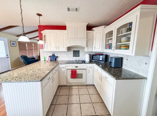 a kitchen with stainless steel appliances granite countertop a stove sink and cabinets