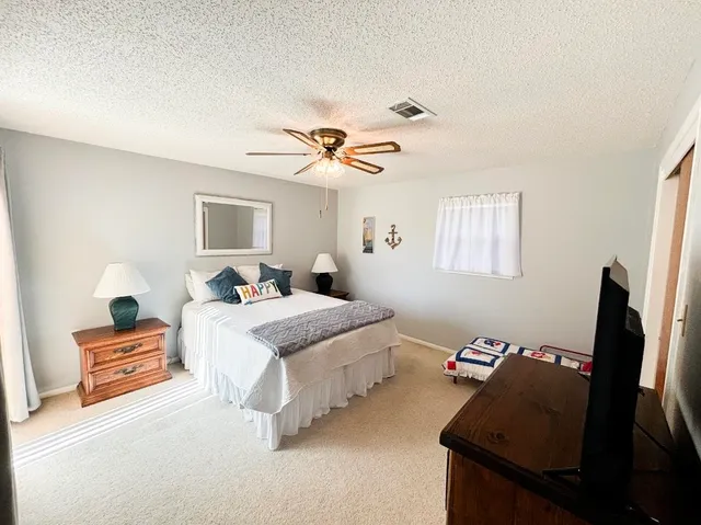 a spacious bedroom with a bed and a chandelier