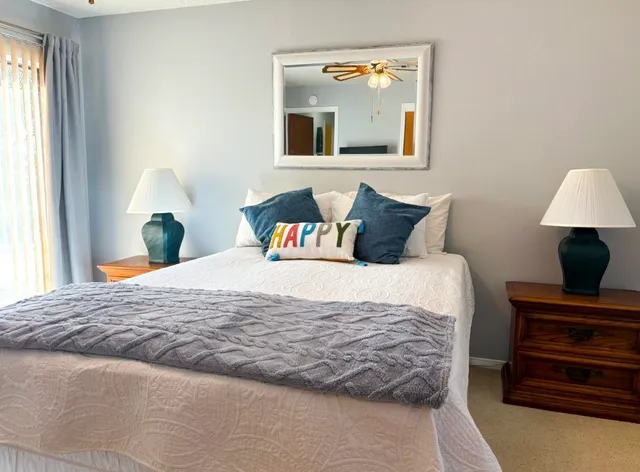 a bedroom with a bed and a lamp on dresser