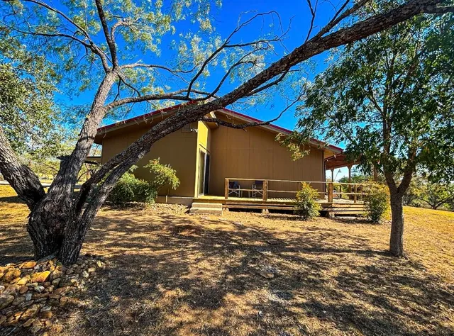 a backyard of a house with barbeque oven a table and chairs under an umbrella