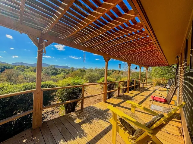a view of a balcony with chairs and wooden floor